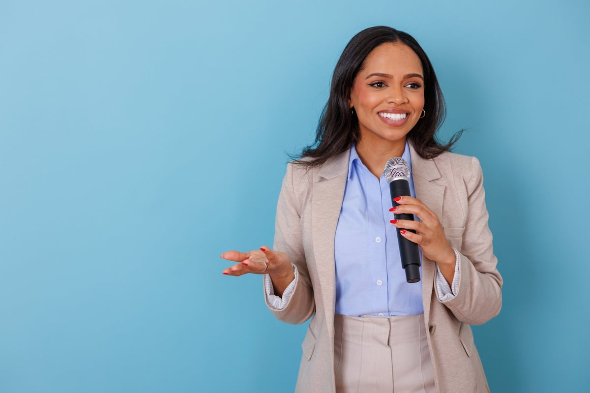 Professional woman speaking into microphone, giving a presentation