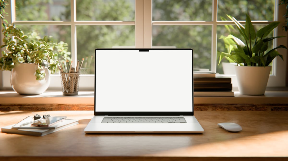 Minimalist bright workspace with laptop on wooden desk near window, soft daylight and green plants, elegant and calm atmosphere