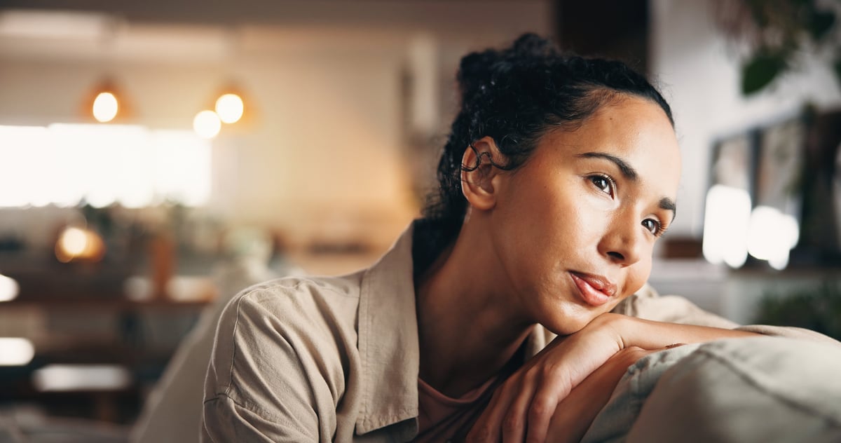 Black and white portrait of a woman in a quiet, contemplative moment, looking away in thought with a calm, reflective expression