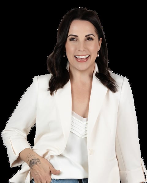 Professional headshot of a woman with dark hair wearing a white blazer over a white top, smiling at the camera against a black background