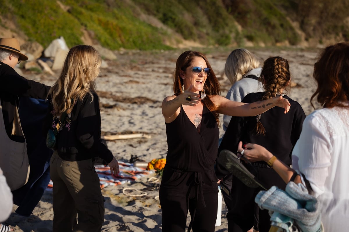 Group of people gathered on a beach having a conversation