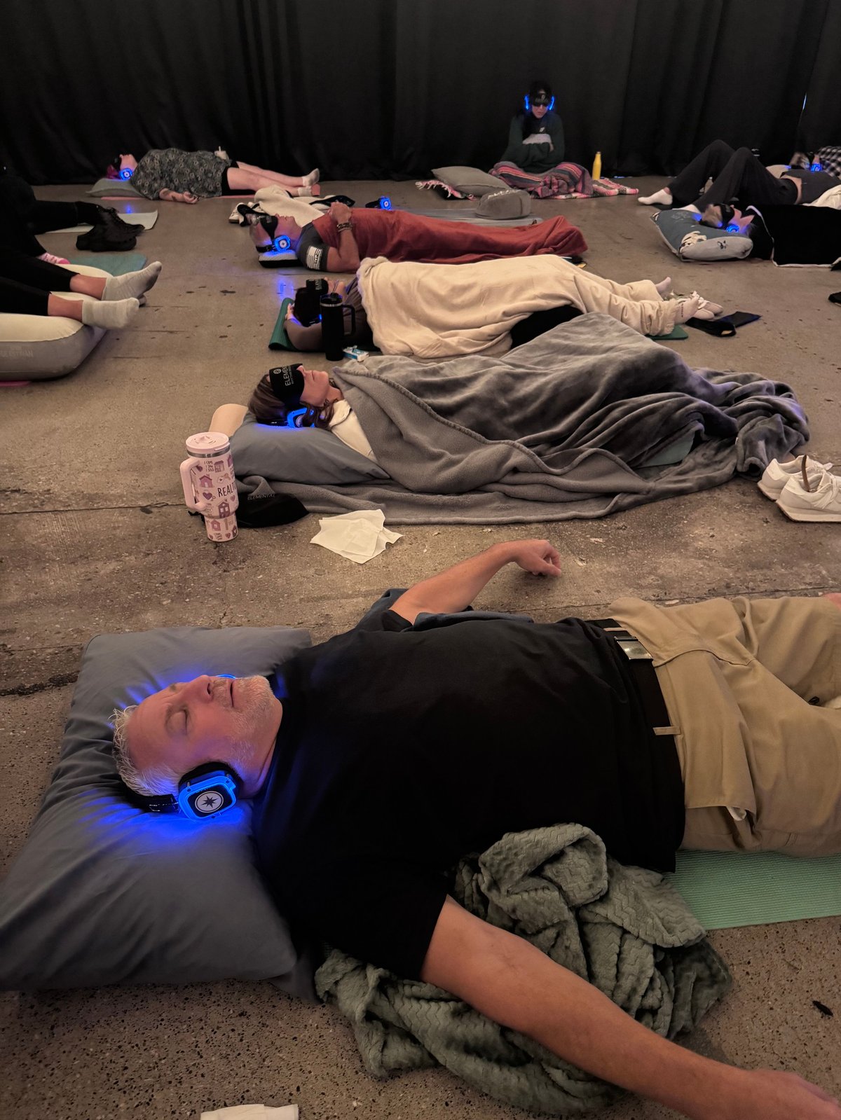 Group of people lying on floor wearing VR headsets during immersive experience session