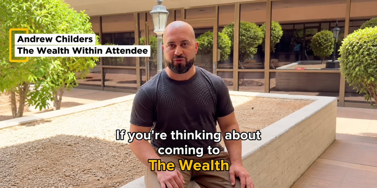 Andrew Childers standing outdoors speaking about attending The Wealth conference, with greenery and modern building in background