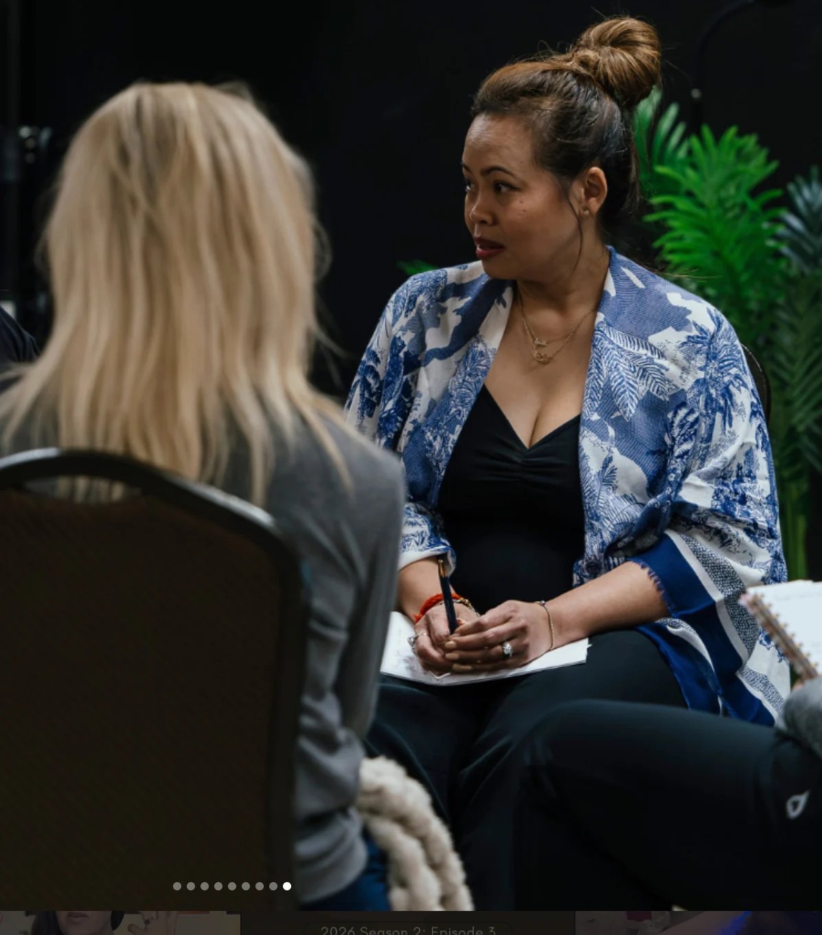 Two women having a conversation in studio setting with green plant in background